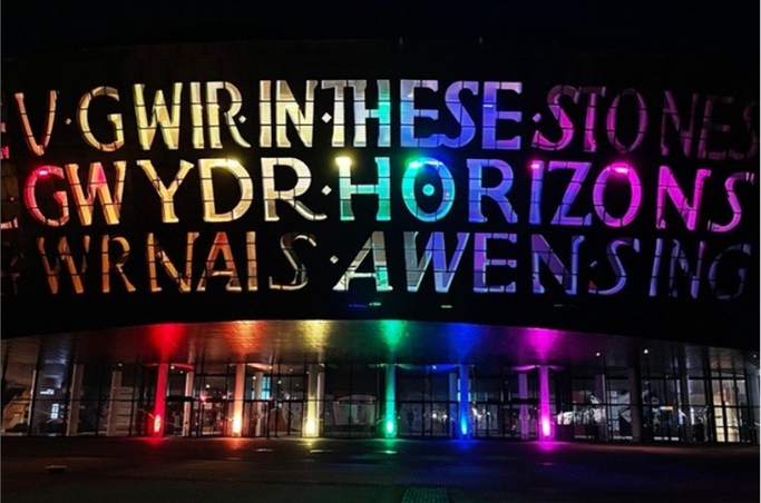 The Wales Millenium Centre is lit up with prode colours.